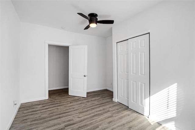 unfurnished bedroom featuring a closet, light wood-type flooring, and ceiling fan