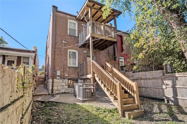 rear view of house with central AC unit and a deck