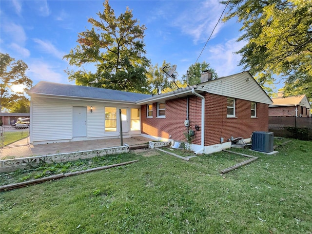 rear view of property featuring cooling unit, a yard, and a patio area