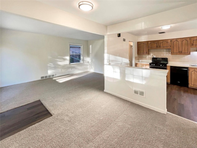 kitchen featuring black appliances, decorative backsplash, and dark carpet