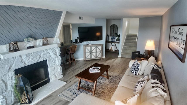 living room with a fireplace and light wood-type flooring