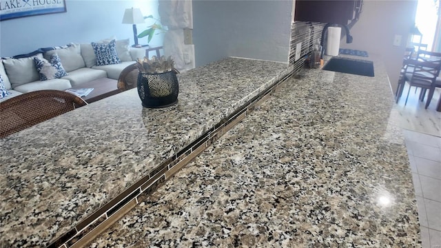 kitchen with tile patterned flooring and stone counters