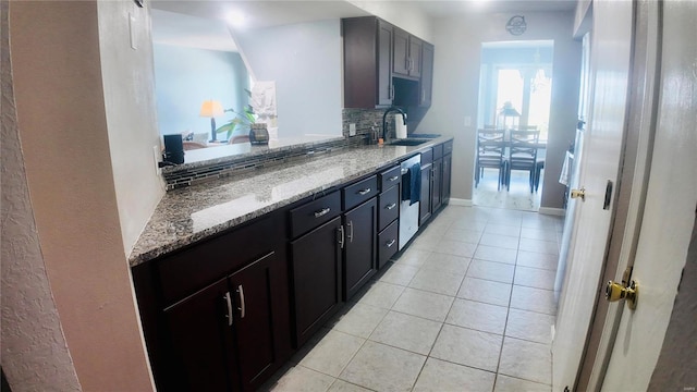 kitchen featuring light stone counters, decorative backsplash, stainless steel dishwasher, and sink