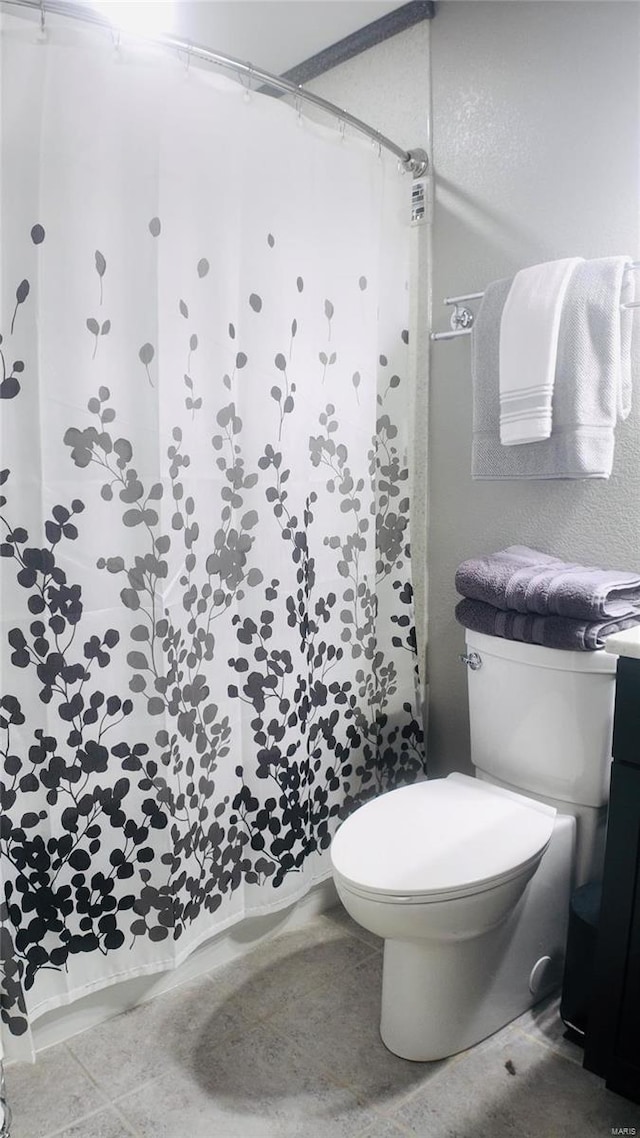 bathroom featuring tile patterned floors, a shower with shower curtain, and toilet