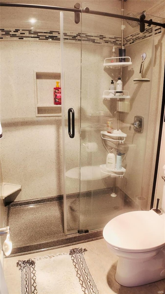 bathroom with walk in shower, tile patterned flooring, and toilet