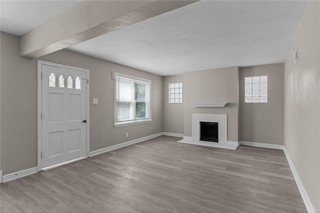 unfurnished living room featuring light wood-type flooring and a fireplace