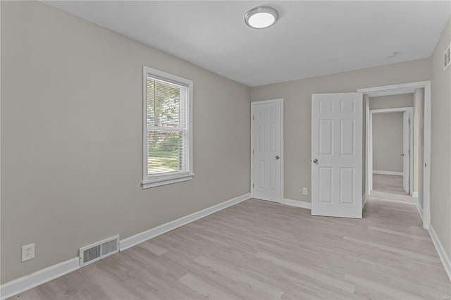 unfurnished bedroom featuring a closet and light hardwood / wood-style floors