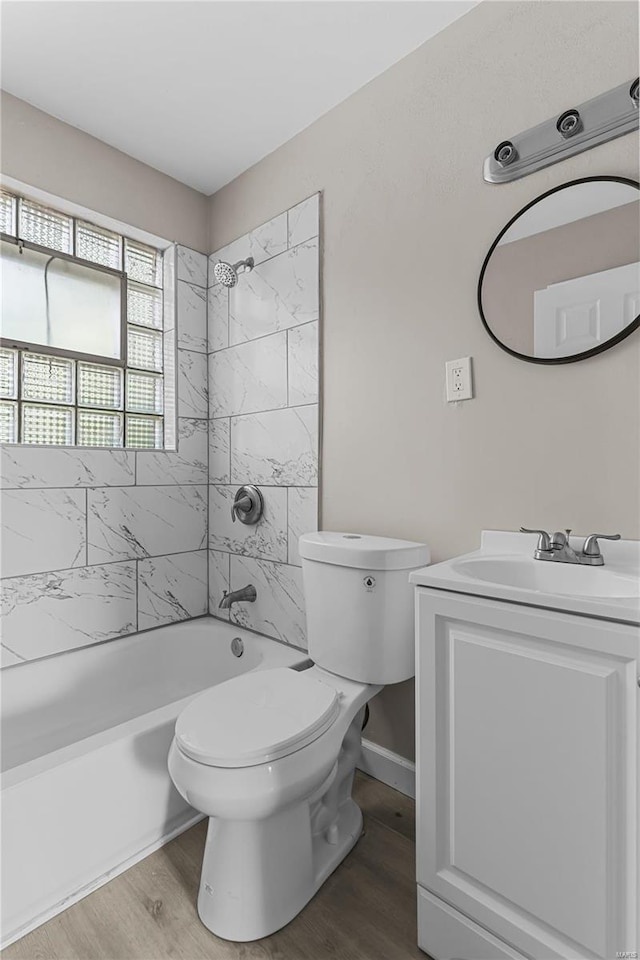 full bathroom with vanity, wood-type flooring, tiled shower / bath, and toilet