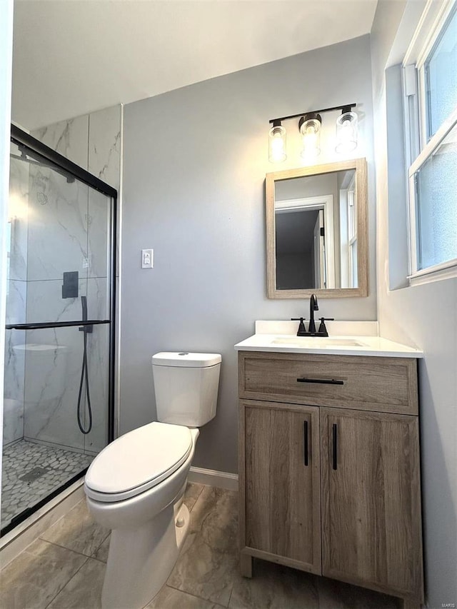 bathroom with a shower with door, vanity, and toilet