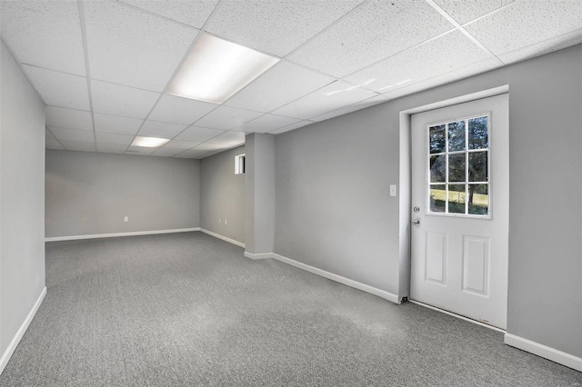 basement featuring carpet floors and a paneled ceiling