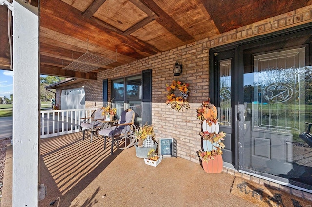 exterior space featuring a porch and brick siding