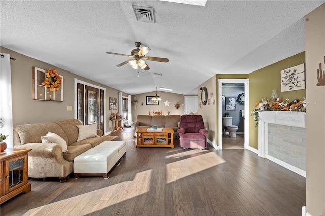 living area featuring dark wood-style flooring, baseboards, a ceiling fan, visible vents, and lofted ceiling