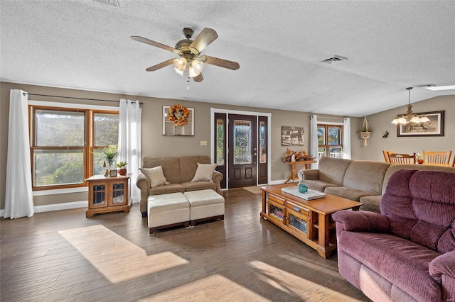 living room featuring plenty of natural light, visible vents, a textured ceiling, and ceiling fan with notable chandelier