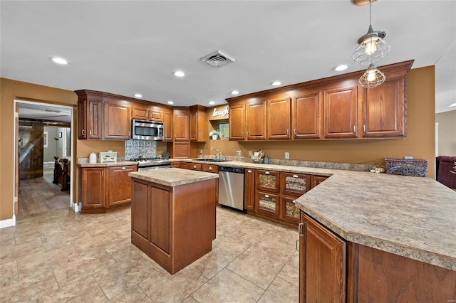 kitchen featuring brown cabinets, a sink, visible vents, and stainless steel appliances