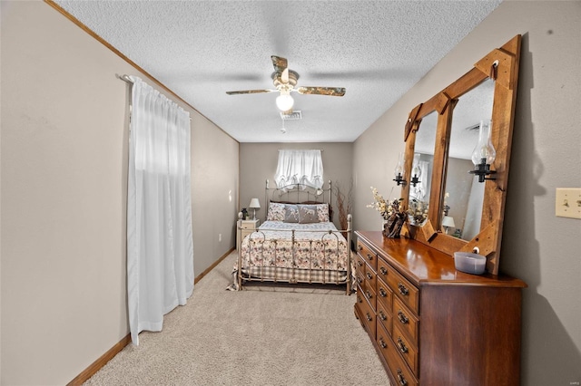 bedroom with light carpet, ceiling fan, visible vents, and a textured ceiling