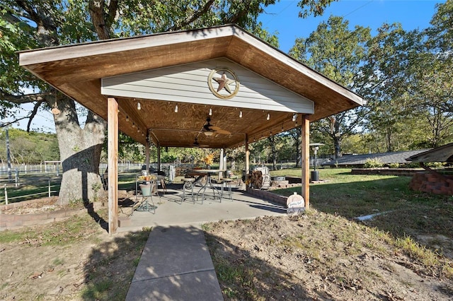 view of property's community featuring a yard, a gazebo, fence, and a patio
