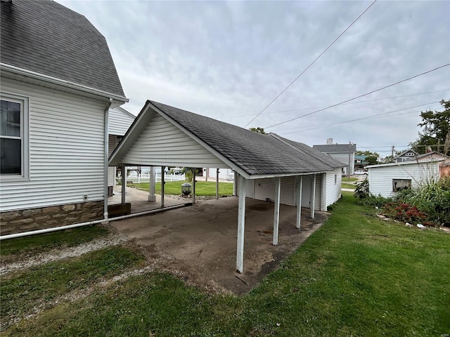 view of parking featuring a yard and a carport