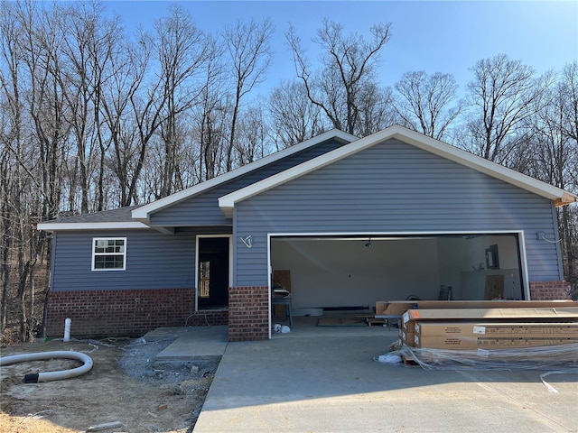 view of front facade featuring driveway, brick siding, and an attached garage