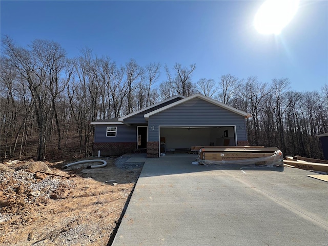 view of front of home featuring concrete driveway, an attached garage, and brick siding