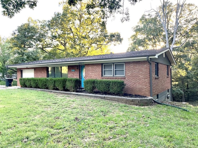 single story home featuring a garage and a front lawn