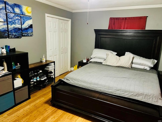 bedroom featuring ornamental molding, light wood-type flooring, and a closet