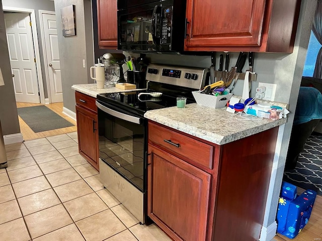 kitchen featuring light tile patterned flooring and electric range