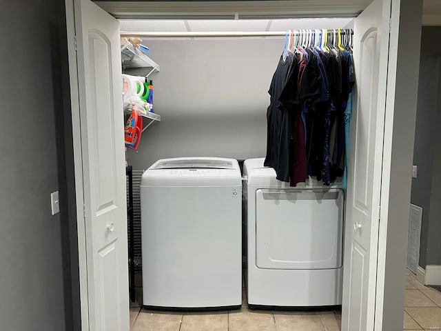 washroom with light tile patterned floors and washer and clothes dryer