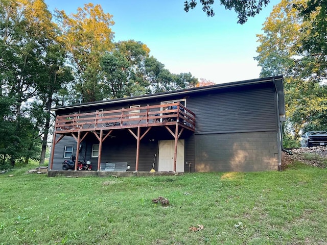 back of property featuring a lawn and a deck