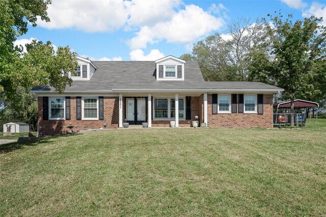 cape cod home featuring french doors, brick siding, and a front lawn