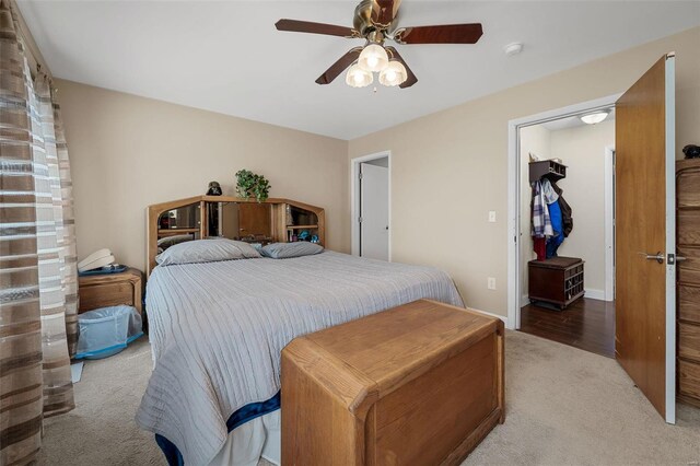 carpeted bedroom with a spacious closet, a closet, and ceiling fan