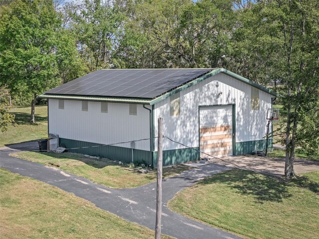 view of outbuilding with a yard and a garage