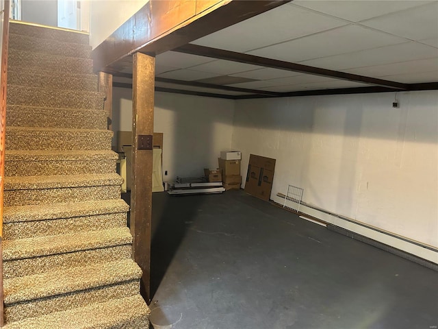 finished basement with stairway and a drop ceiling