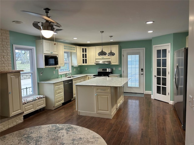 kitchen with dark wood finished floors, appliances with stainless steel finishes, a center island, a sink, and recessed lighting