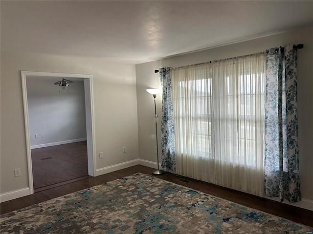 unfurnished room featuring visible vents, baseboards, and wood finished floors