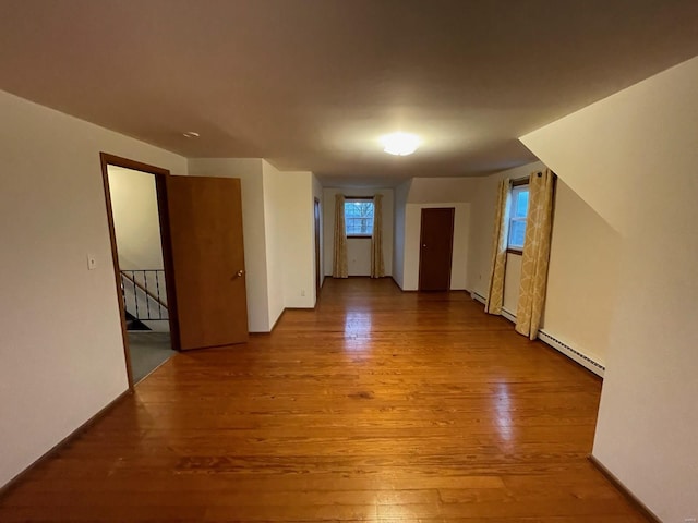 spare room featuring a baseboard radiator and wood finished floors