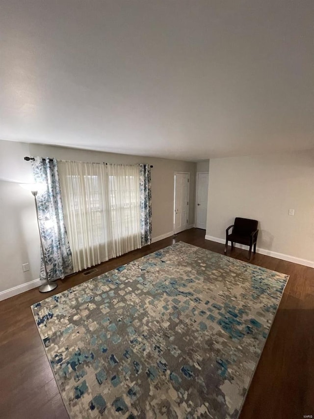 living area featuring baseboards and wood finished floors