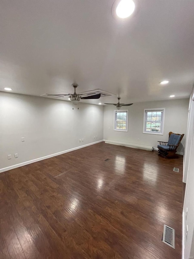 unfurnished room featuring ceiling fan, dark wood-style flooring, visible vents, and baseboards