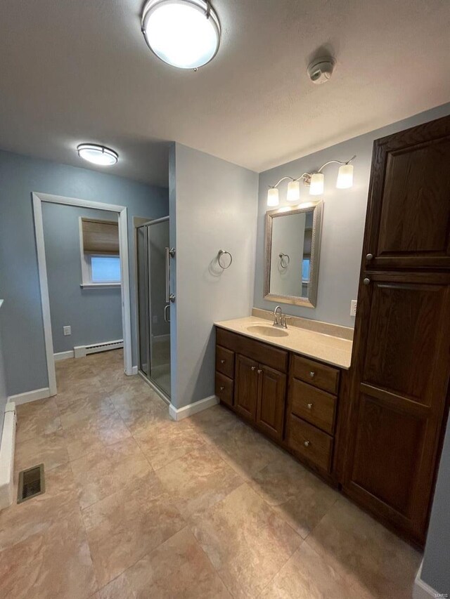 full bathroom featuring a baseboard heating unit, vanity, visible vents, baseboards, and a stall shower