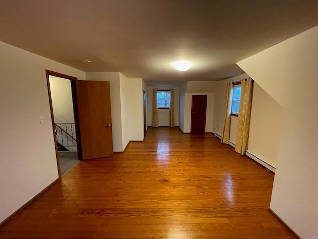 empty room featuring a baseboard radiator and wood finished floors