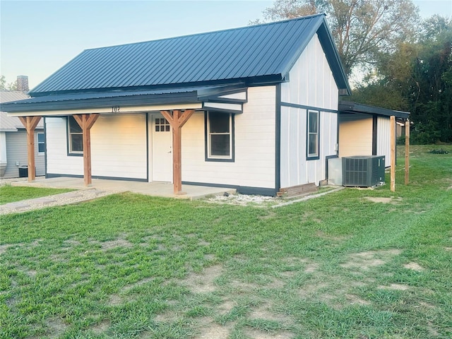 rear view of house featuring cooling unit and a yard