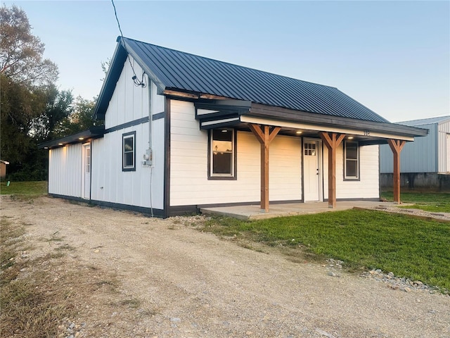 rear view of property with board and batten siding and metal roof