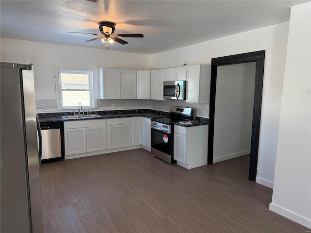 kitchen with stainless steel appliances, dark wood-style flooring, backsplash, and dark countertops