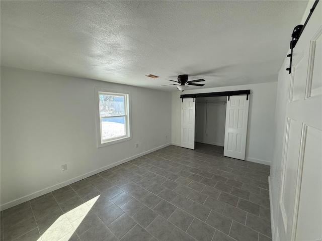 unfurnished bedroom featuring a closet, baseboards, ceiling fan, and a textured ceiling