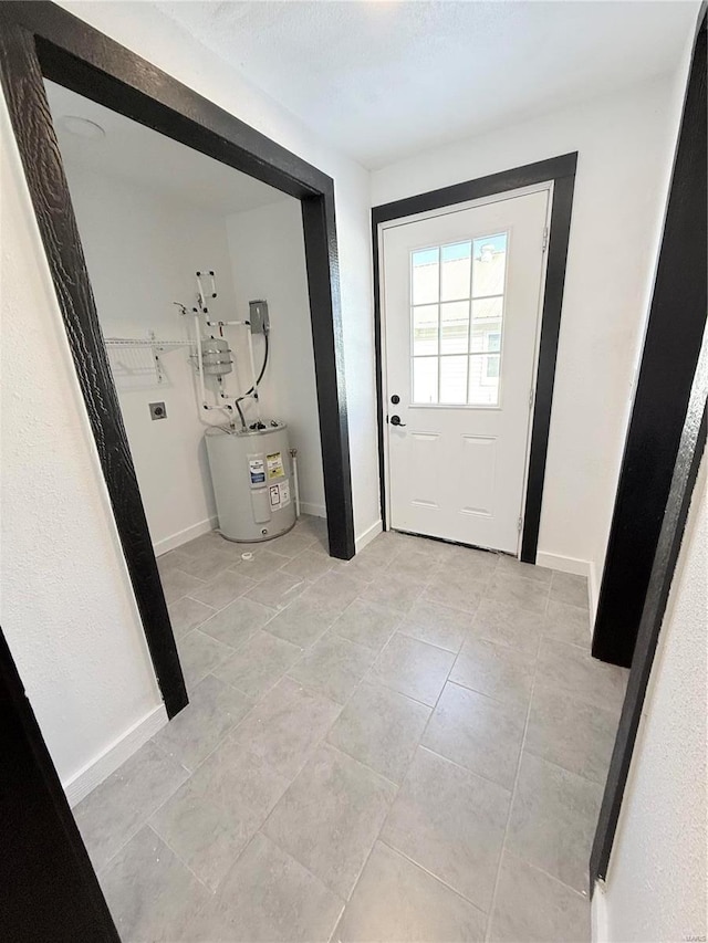 doorway with water heater, baseboards, and light tile patterned flooring