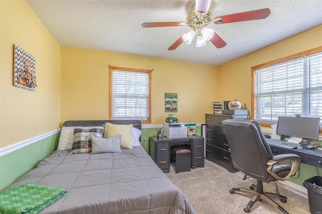 bedroom featuring a textured ceiling, ceiling fan, and light colored carpet