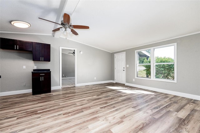 unfurnished living room featuring vaulted ceiling with beams, light hardwood / wood-style floors, and crown molding