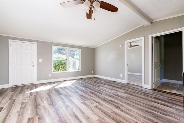 unfurnished living room with ceiling fan, crown molding, wood finished floors, baseboards, and vaulted ceiling with beams