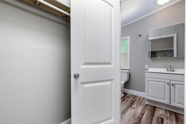 bathroom featuring ornamental molding, vanity, toilet, and hardwood / wood-style flooring