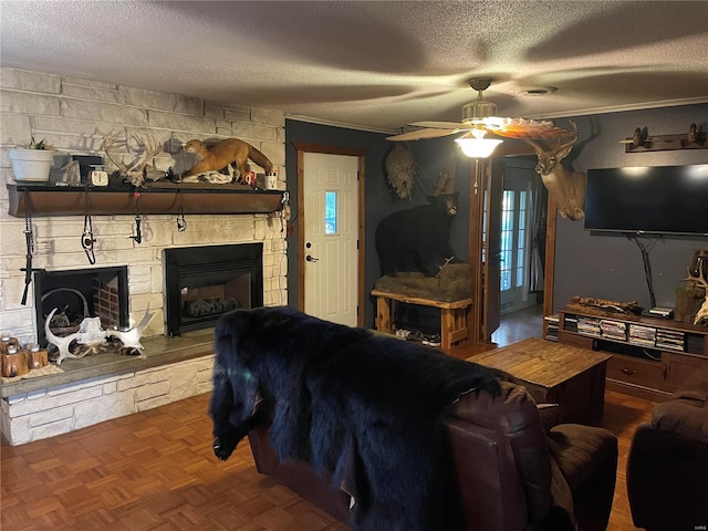 living room with dark parquet flooring, a textured ceiling, ceiling fan, and a stone fireplace