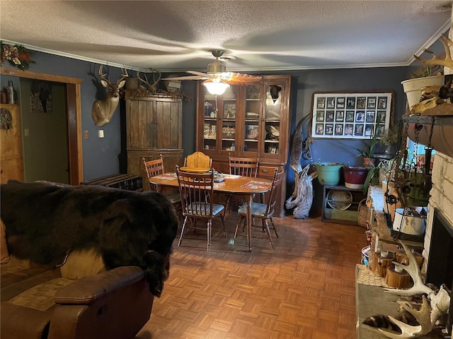 dining room featuring a textured ceiling, parquet floors, ornamental molding, and ceiling fan